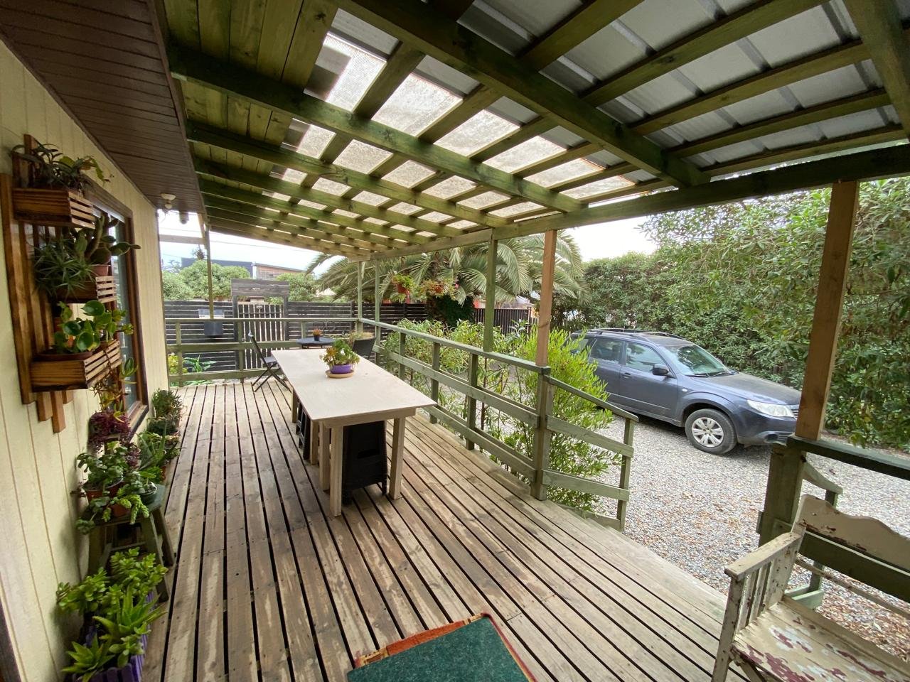 Patio amplio con asientos, mesas, vegetación y zonas techadas