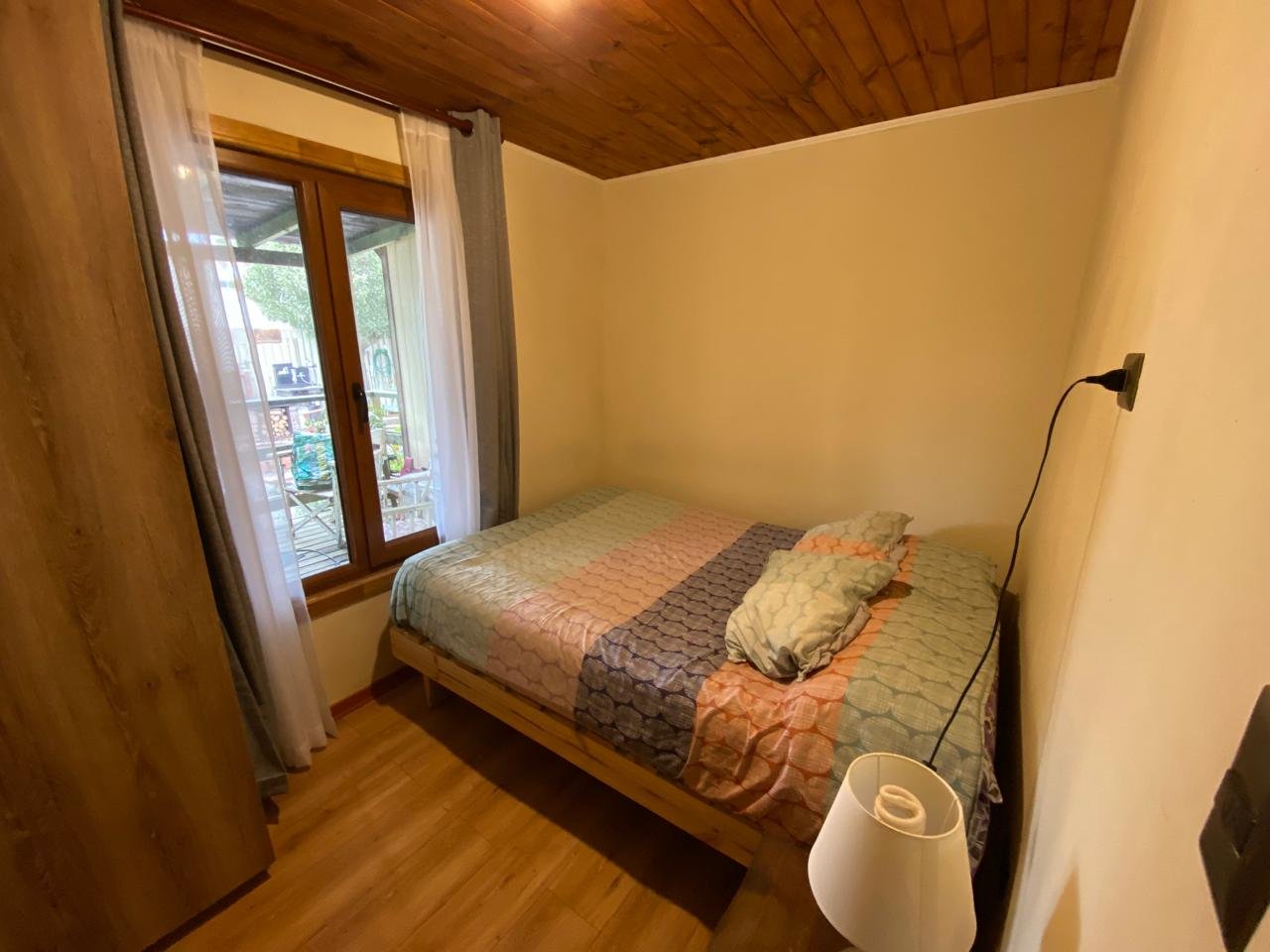 Dormitorio con cama doble y ventana al patio