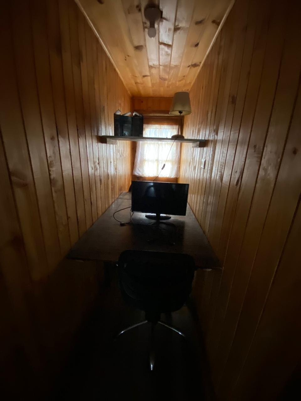 Pequeño espacio de trabajo con escritorio, silla y monitor